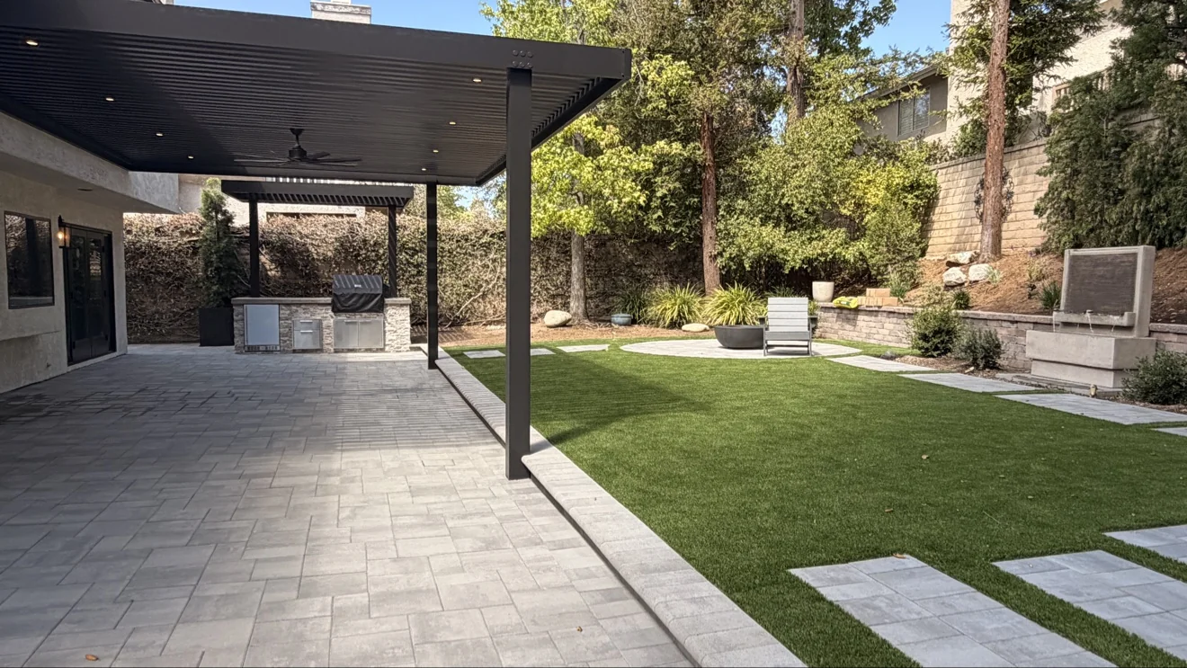 Louvered pergola over stone outdoor kitchen by Moda Outdoor Living in Westlake Village, CA — luxury outdoor living design and build