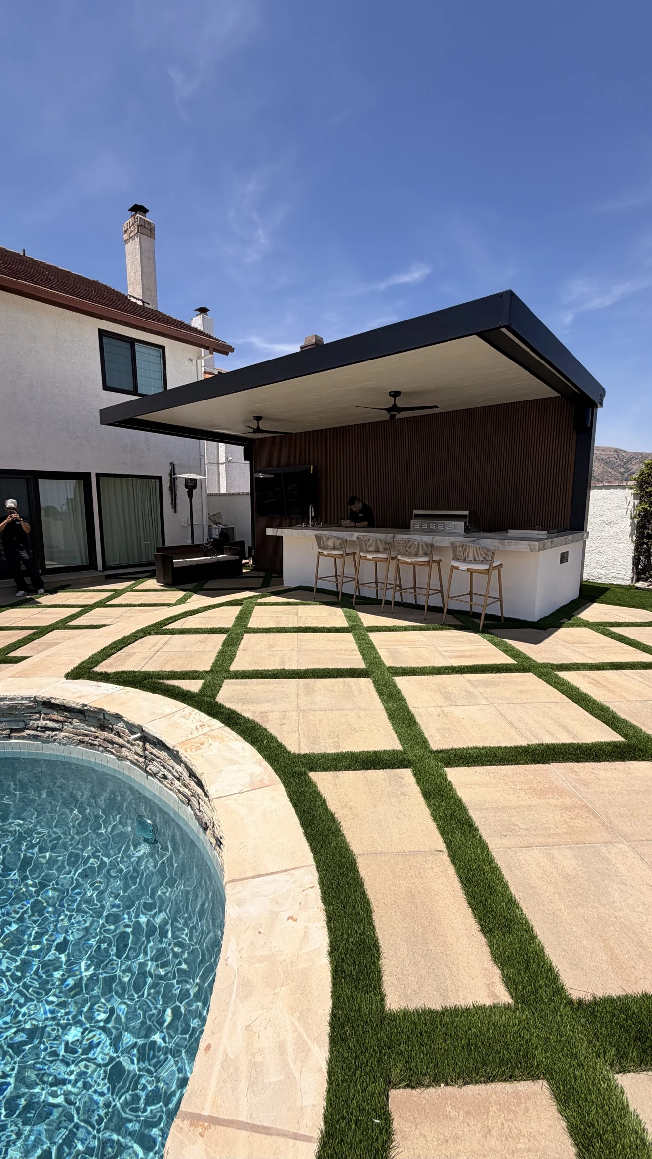 Outdoor bar under a black pergola by Moda Outdoor Living in Porter Ranch, CA — luxury outdoor living design and build