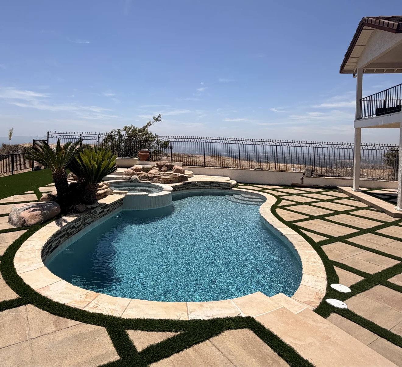 Curved pool with rock waterfall by Moda Outdoor Living in Porter Ranch, CA — luxury outdoor living design and build