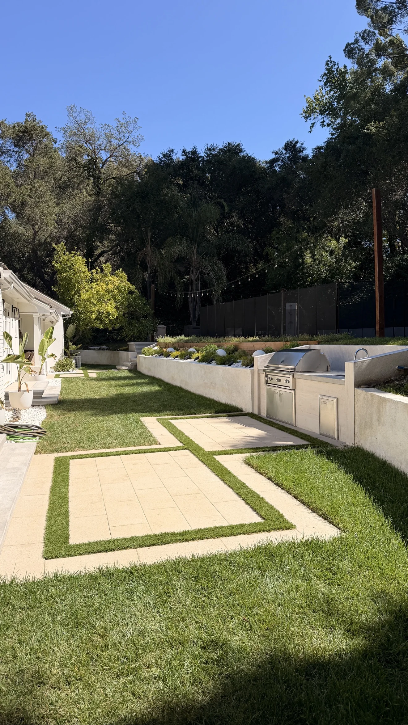 Porcelain paver and turf grid patio by Moda Outdoor Living in Encino, CA — luxury outdoor living design and build
