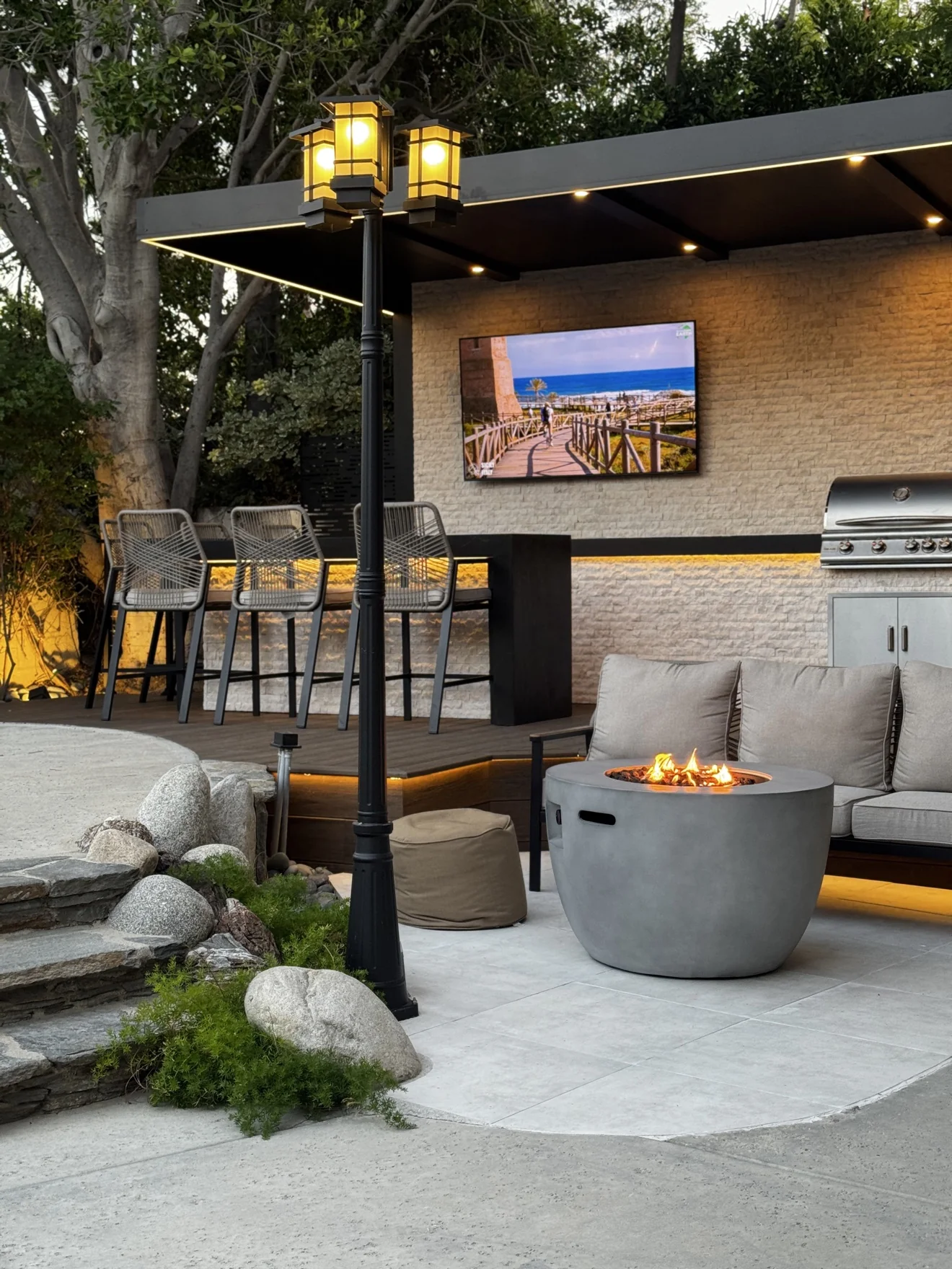Outdoor bar with TV and grill at dusk by Moda Outdoor Living in Porter Ranch, CA — luxury outdoor living design and build