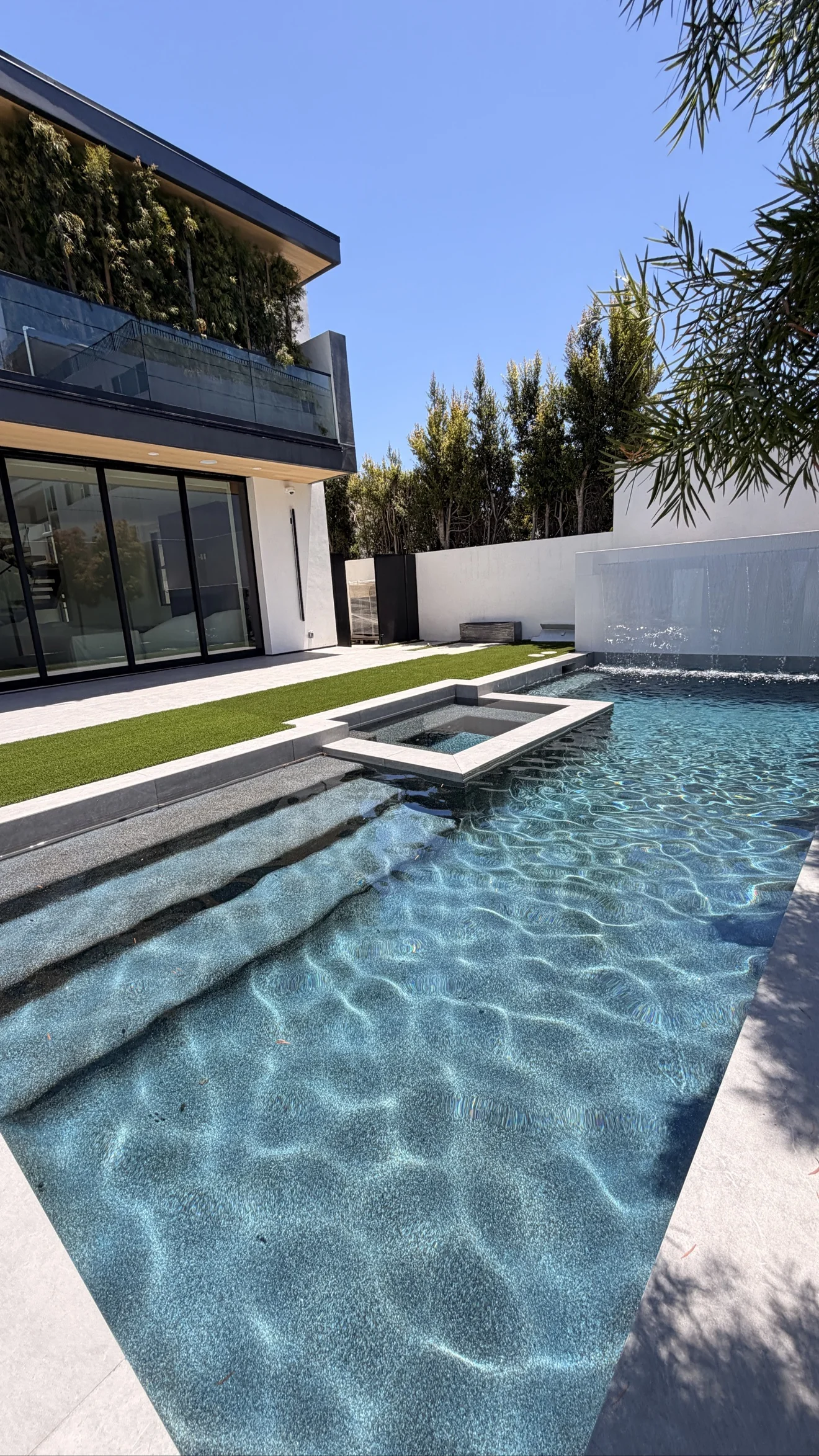 Modern pool with water wall and spa by Moda Outdoor Living in Beverly Hills, CA — luxury outdoor living design and build