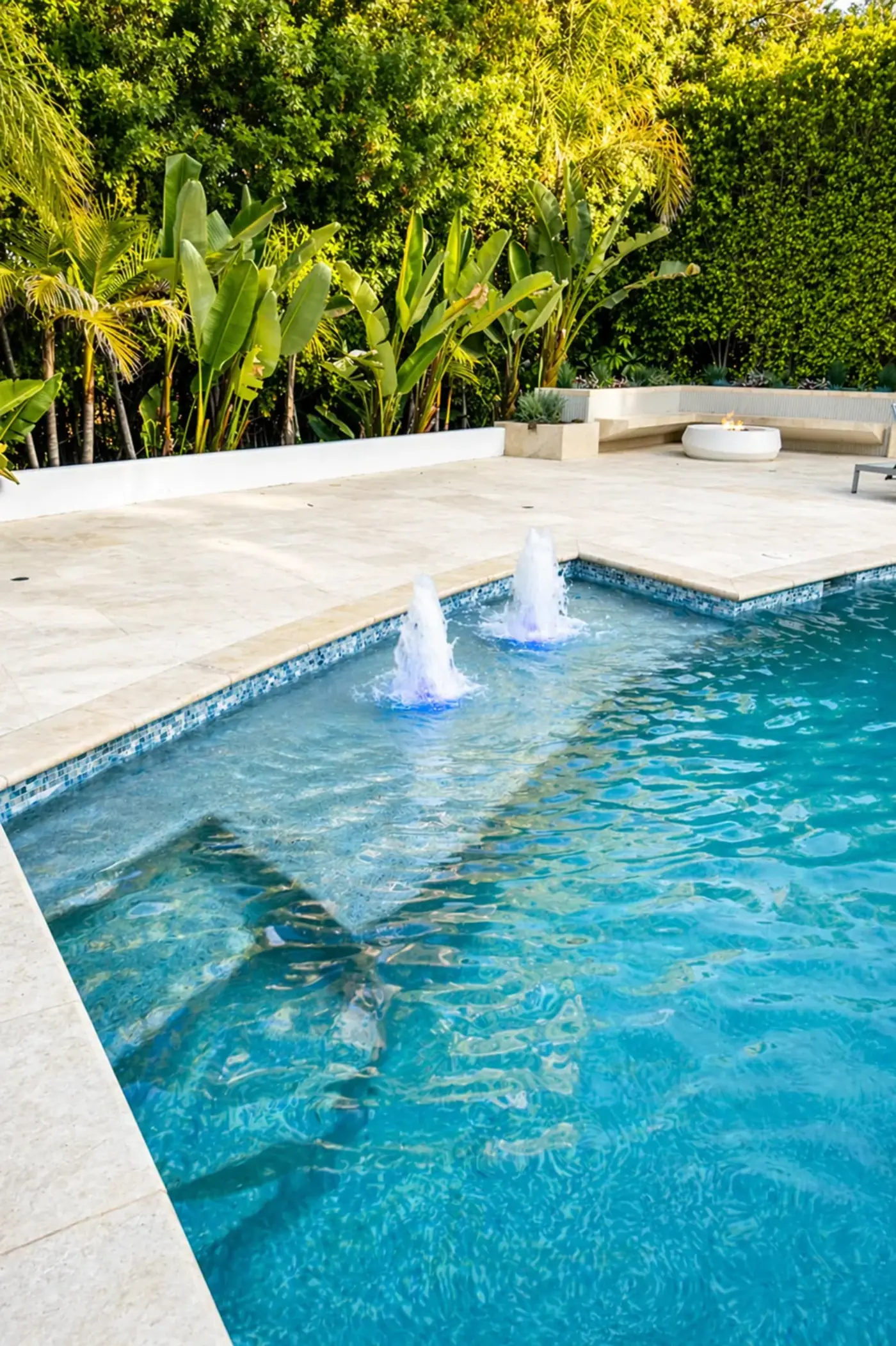 Travertine Pool Deck with Bubbler Fountains & Glass Tile — luxury outdoor living design and build by Moda Outdoor Living