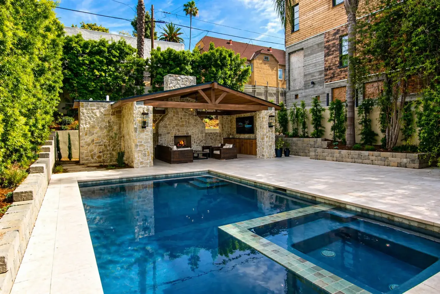 Stone Cabana with Fireplace, TV Lounge, Pool & Spa — luxury outdoor living design and build by Moda Outdoor Living