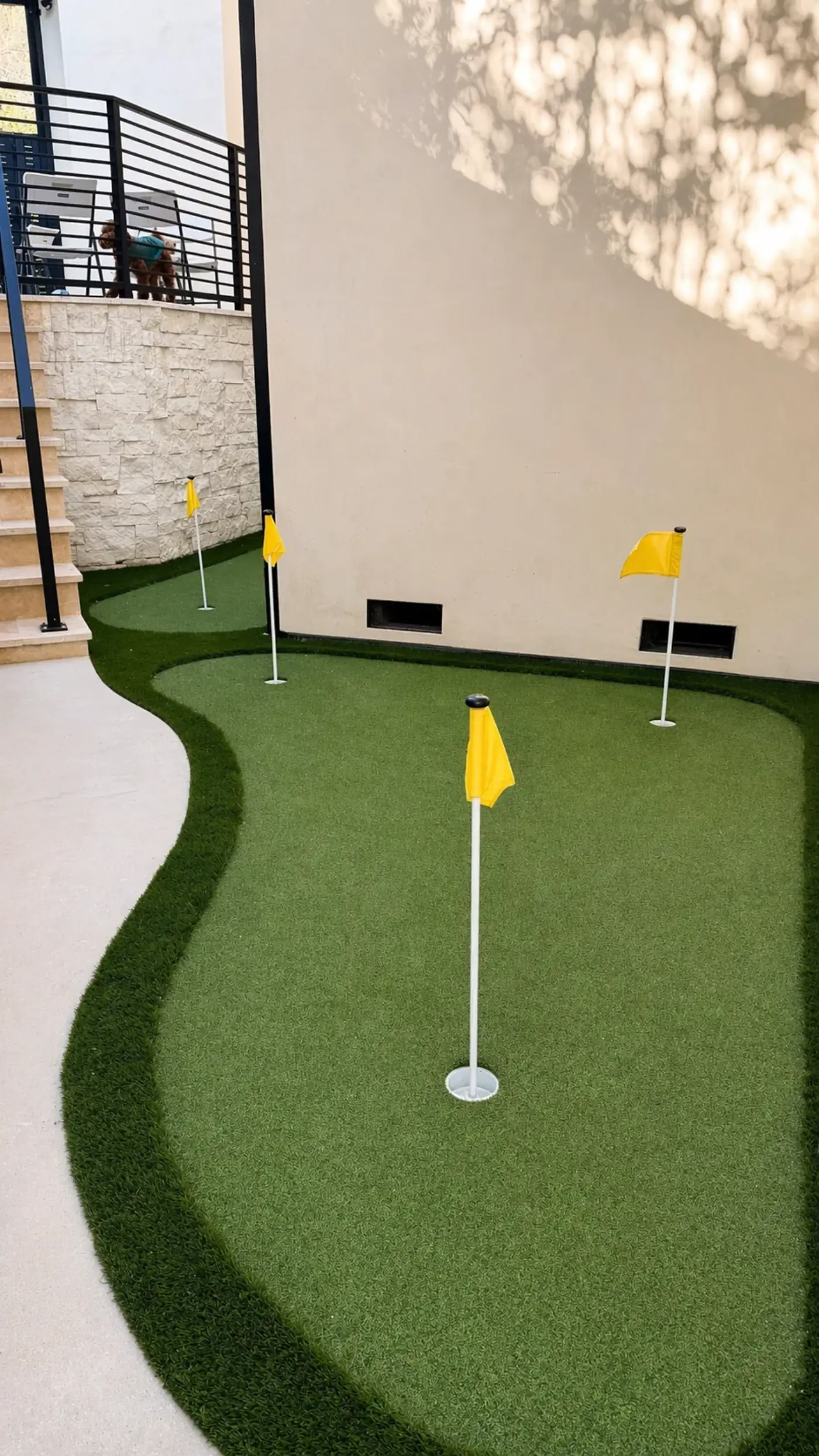 Putting Green with Tiered Turf and Stair Access — luxury outdoor living design and build by Moda Outdoor Living