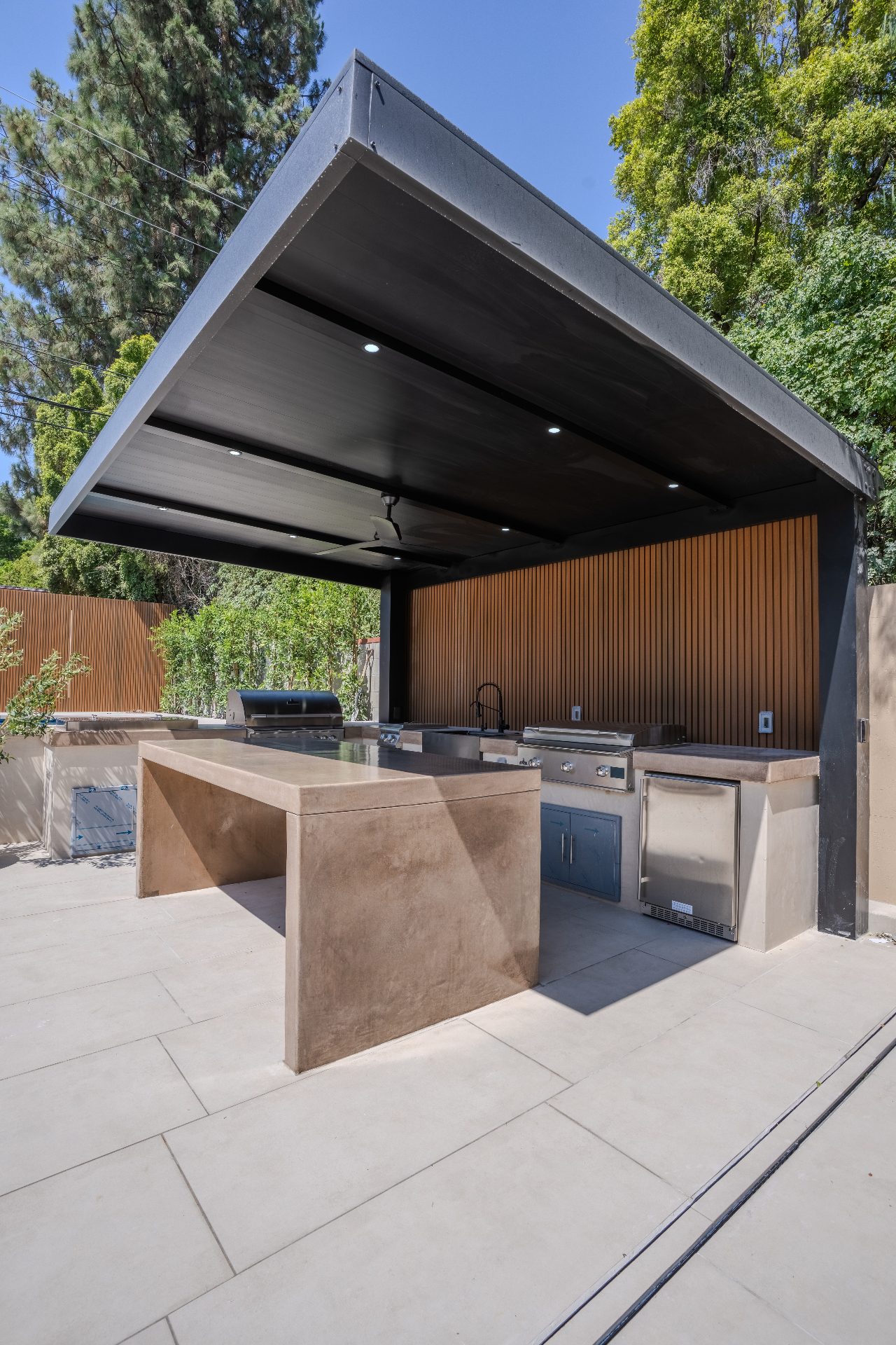 Outdoor kitchen with cantilever pergola showing durable material selections