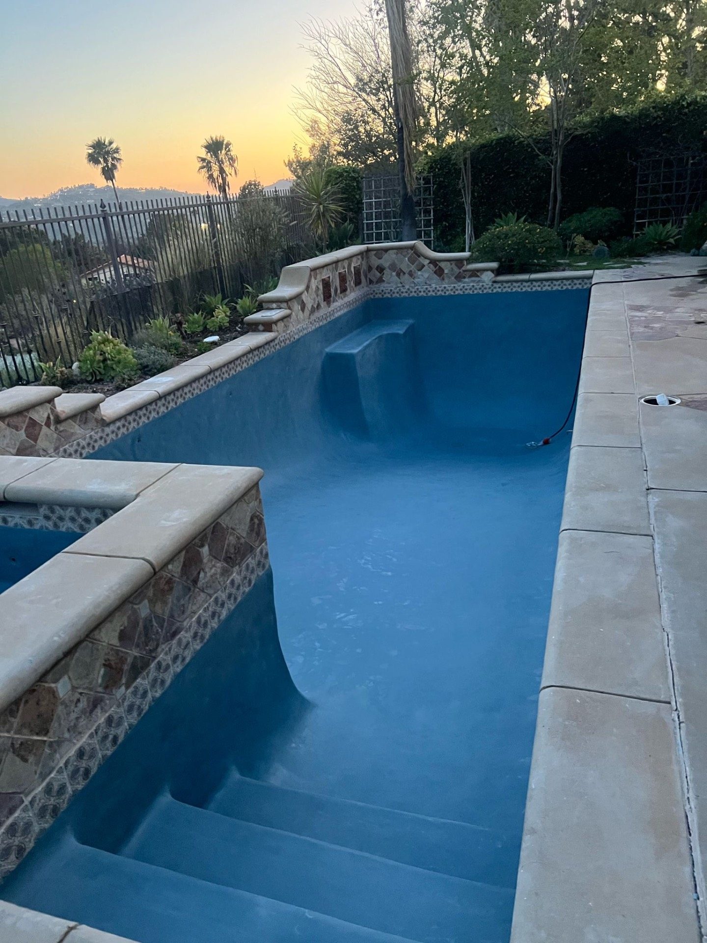 Fresh blue pebble plaster applied to restored pool