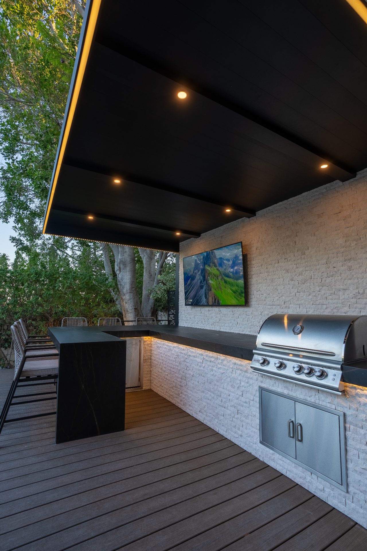 Well-lit hillside backyard with integrated security lighting at twilight