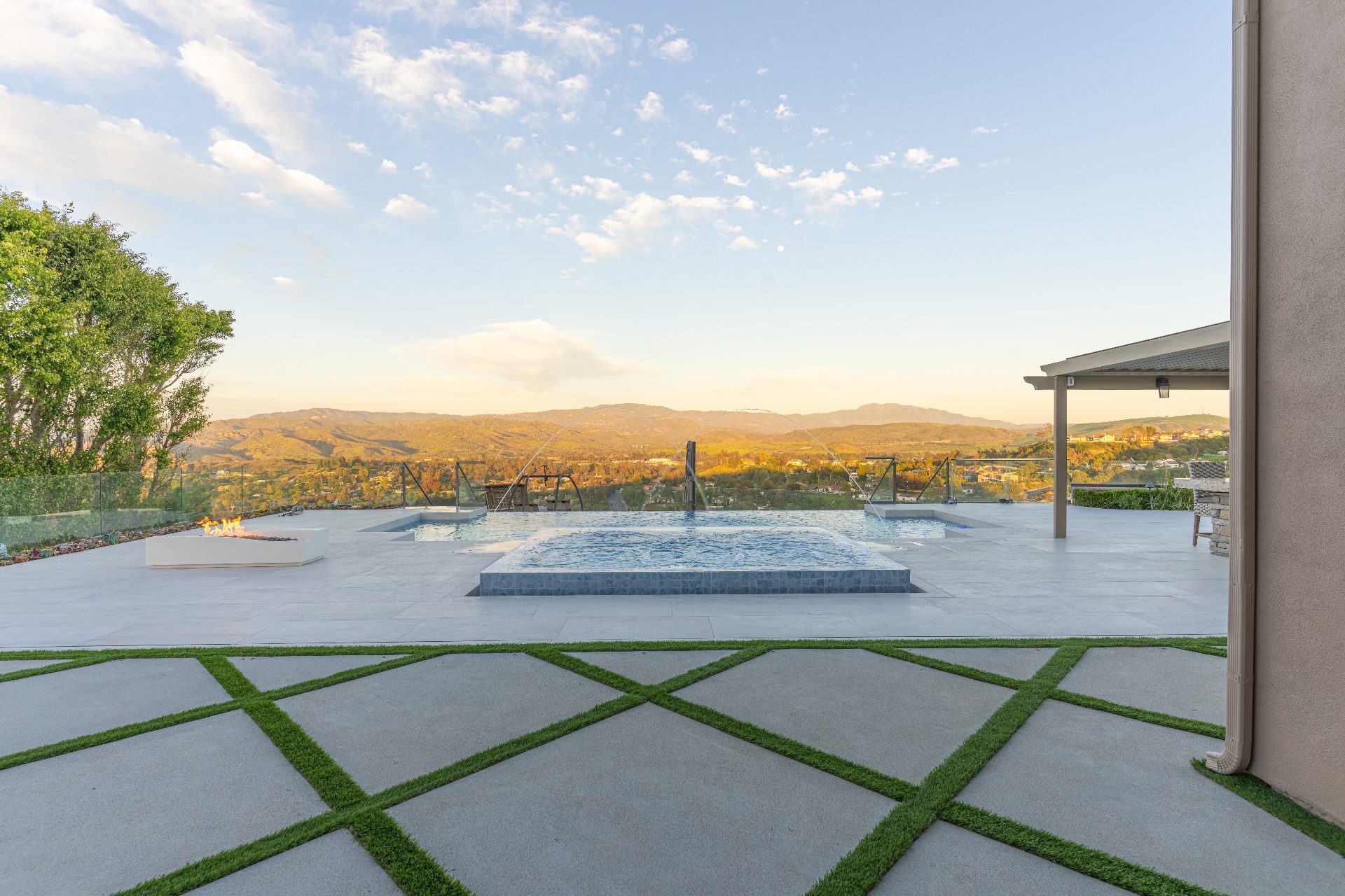Outdoor fire table dining setup with hillside view at dusk