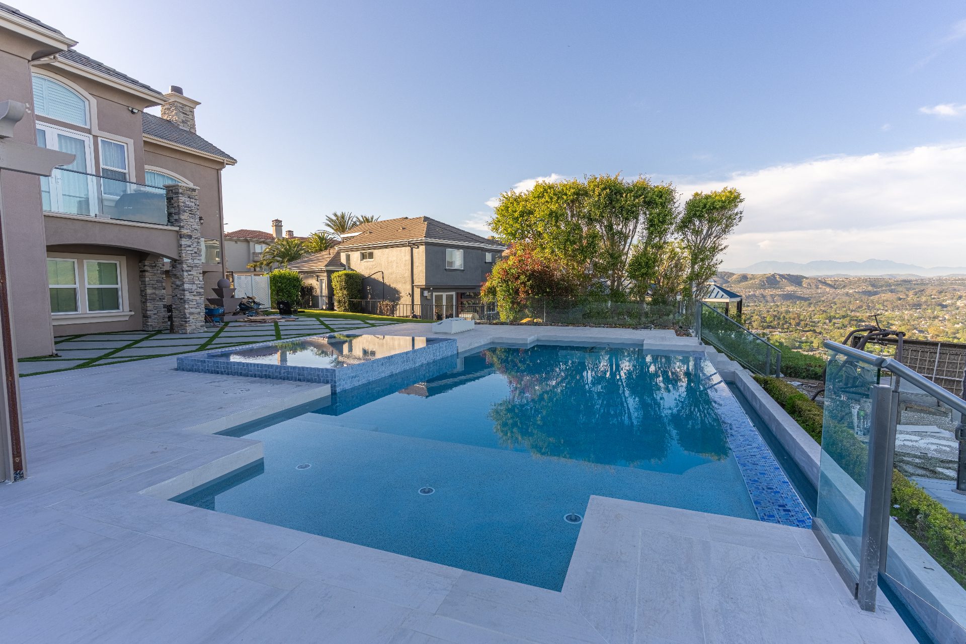 Crystal clear saltwater pool with glass railing in daytime