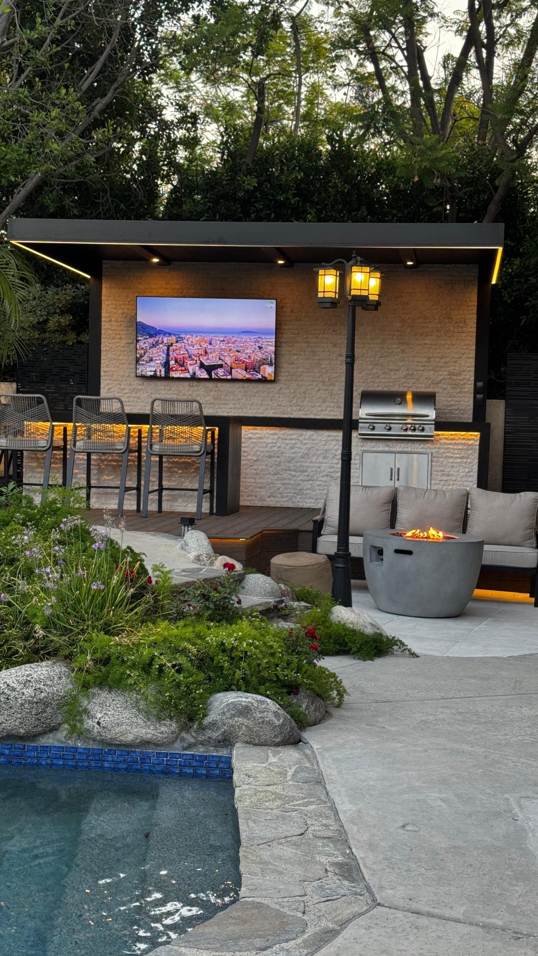 Modern pool with baja shelf and artificial turf border at sunset in Los Angeles