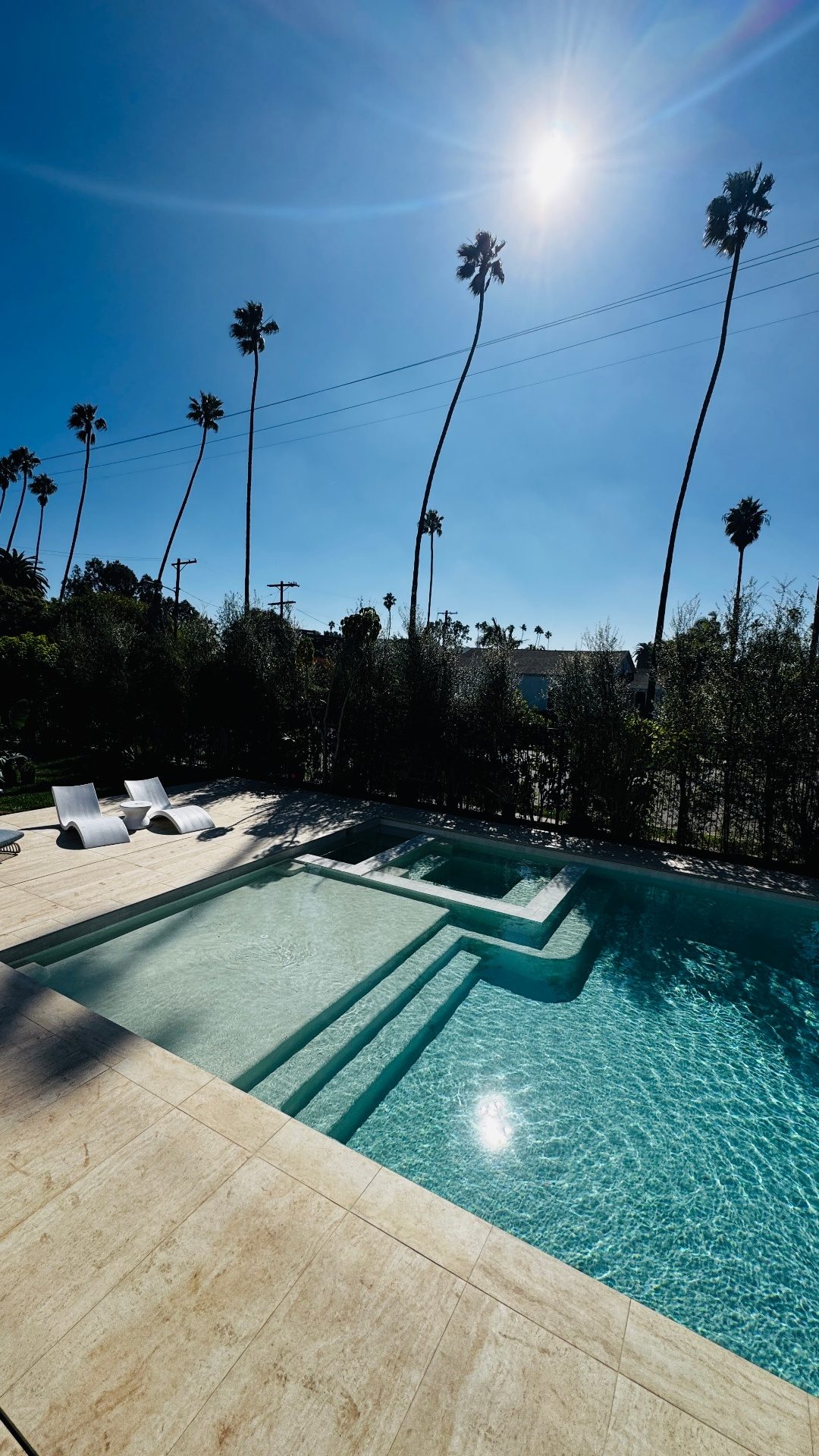 Motorized aluminum pergola next to a swimming pool with lounge seating in Los Angeles