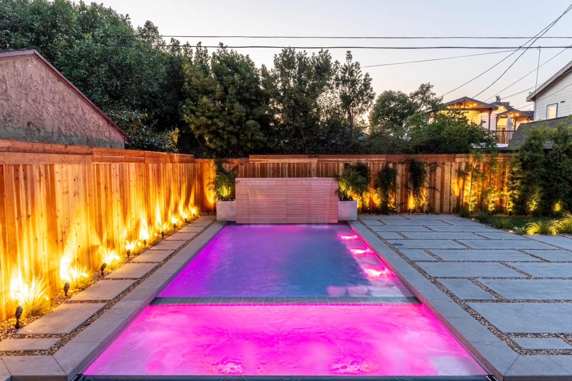 Pool with pink LED lighting at twilight in luxury LA backyard