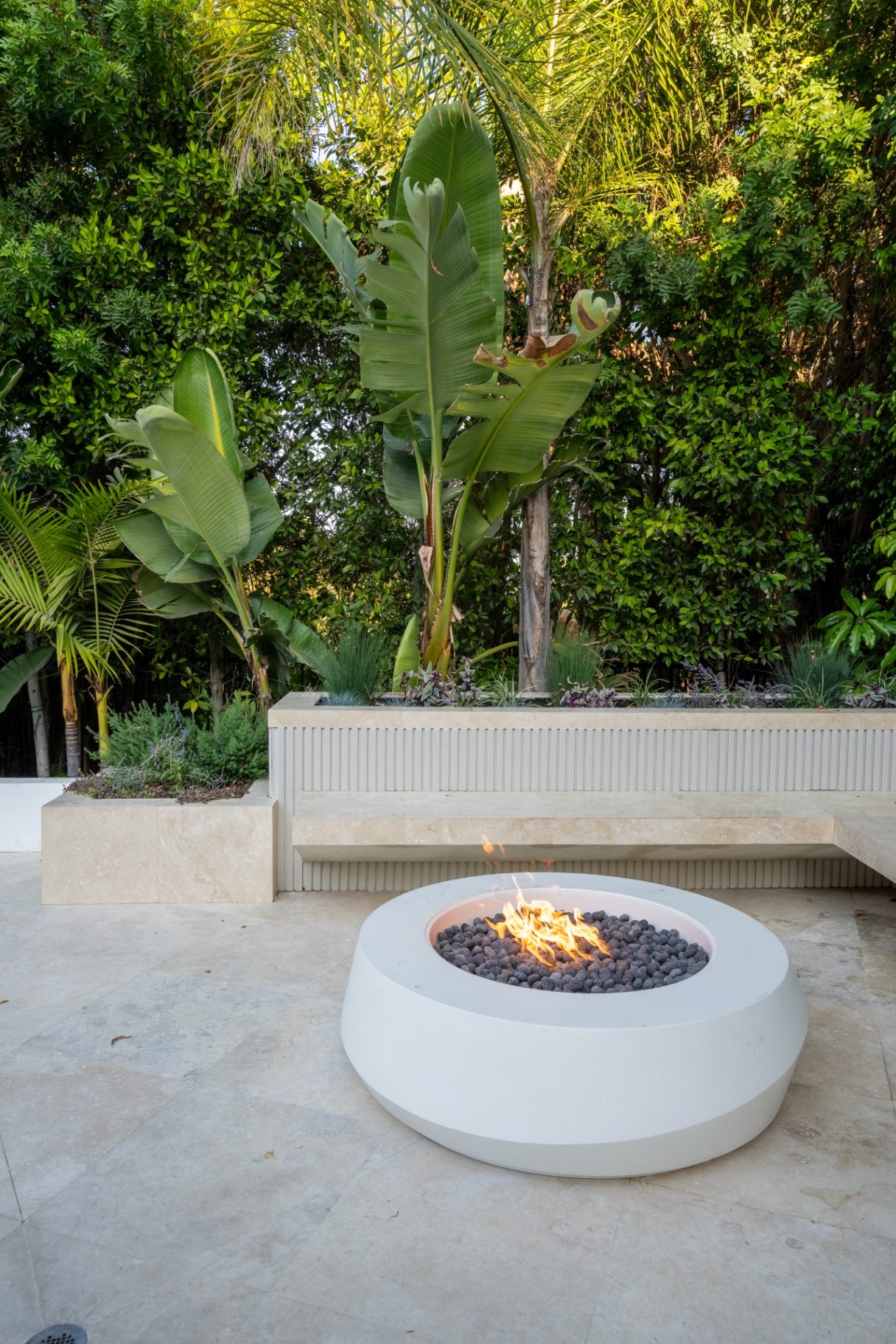Modern fire pit with landscape lighting at dusk
