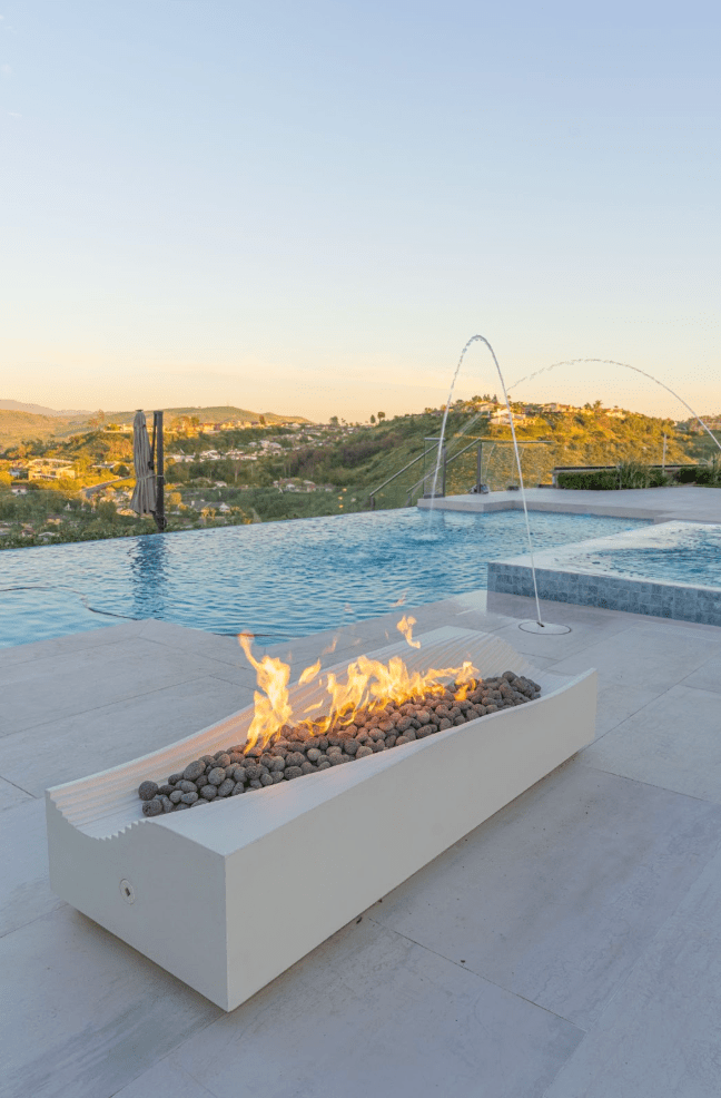 Deck jets creating graceful water arches into a backyard pool in Southern California