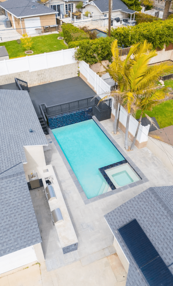 Small backyard with open layout using paver patterns and planters to subtly define lounging and dining zones
