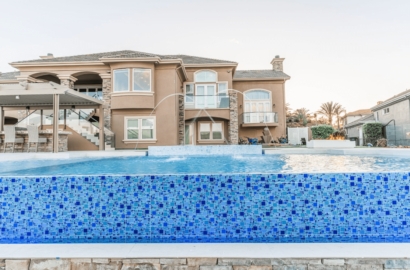 Backyard pool in Southern California with Baja shelf, water features, and shaded lounge area
