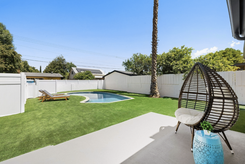 Beautifully landscaped backyard with pool, pavers, and integrated greenery showing cohesive outdoor design


