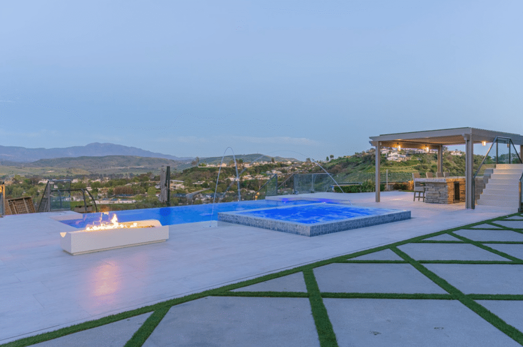 Modern backyard swimming pool with clean lines and water features, representing a custom pool build in Los Angeles